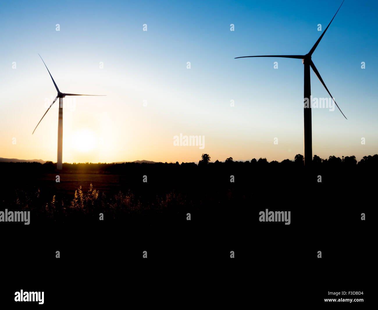 Windkraftanlagen auf dem Land einen Sonnenuntergang. Silhouette-Version. Konzept der Wiedergeburt von Ökostrom Stockfoto