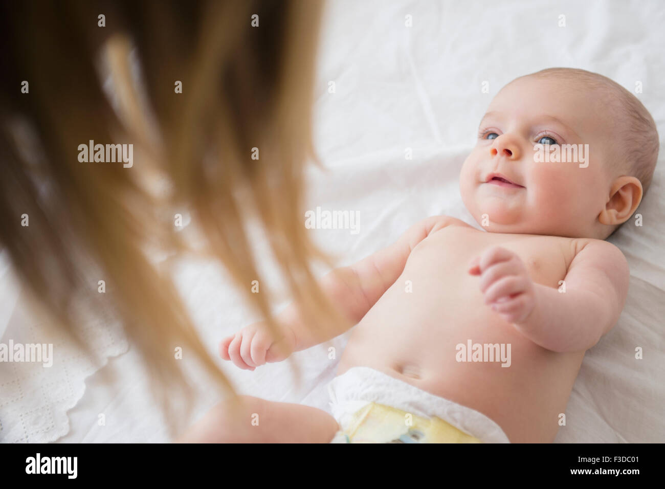 Mutter mit Baby Girl (2-5 Monate) auf Bett spielen Stockfoto