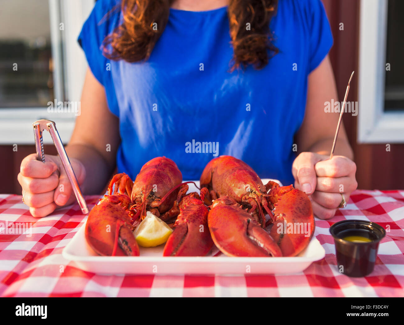 Ansicht der Tabelle mit Lobster Essen und Frau zu essen vorbereiten Stockfoto