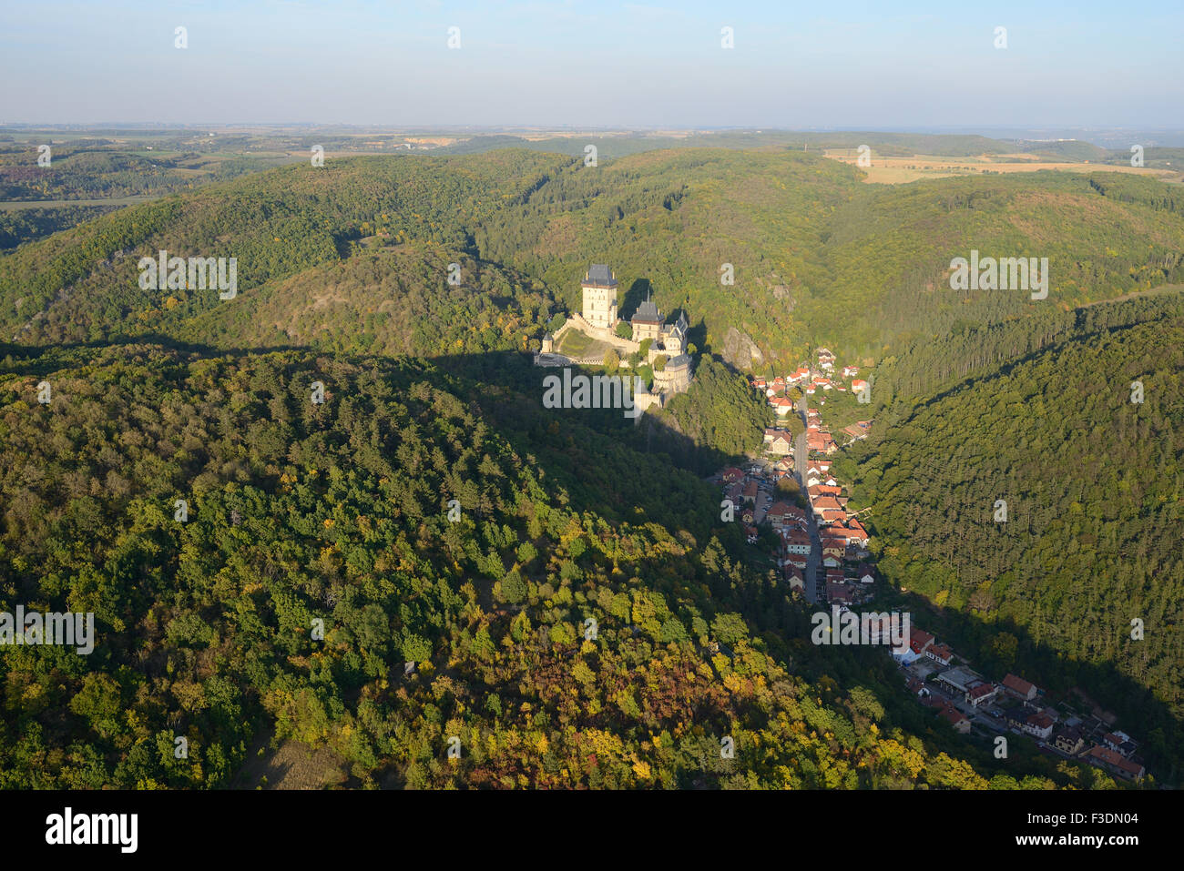 LUFTAUFNAHME. Schloss Karlstejn mit Blick auf die gleichnamige Marktstadt im Talboden. Böhmen, Tschechische Republik. Stockfoto