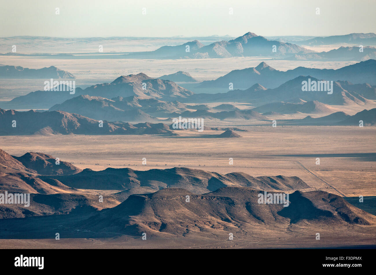 Vereinzelte Bergrücken am Rande der Namib-Wüste mit Küstennebel hinter, Luftaufnahme, NamibRand Nature Reserve, Namibia Stockfoto