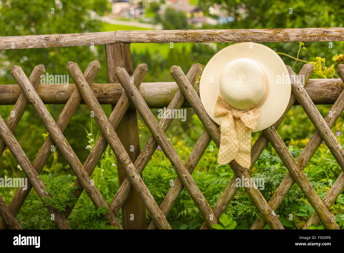 Weibliche Sommerhut hängen rustikale Holzzaun. Kleinen Griff gedreht Stockfoto