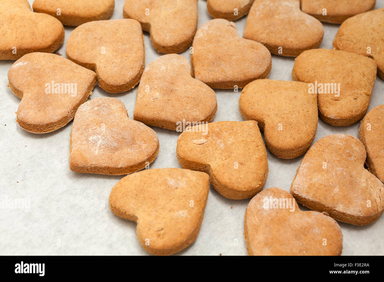 Cookies auf Backpapier in Herzform Stockfoto