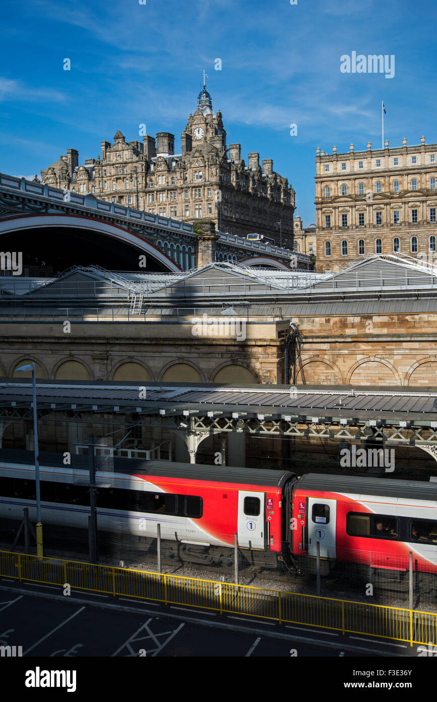 Ein natives Zug sitzen an Waverley Station Edinburgh mit North Bridge und das Balmoral Hotel im Hintergrund. Stockfoto