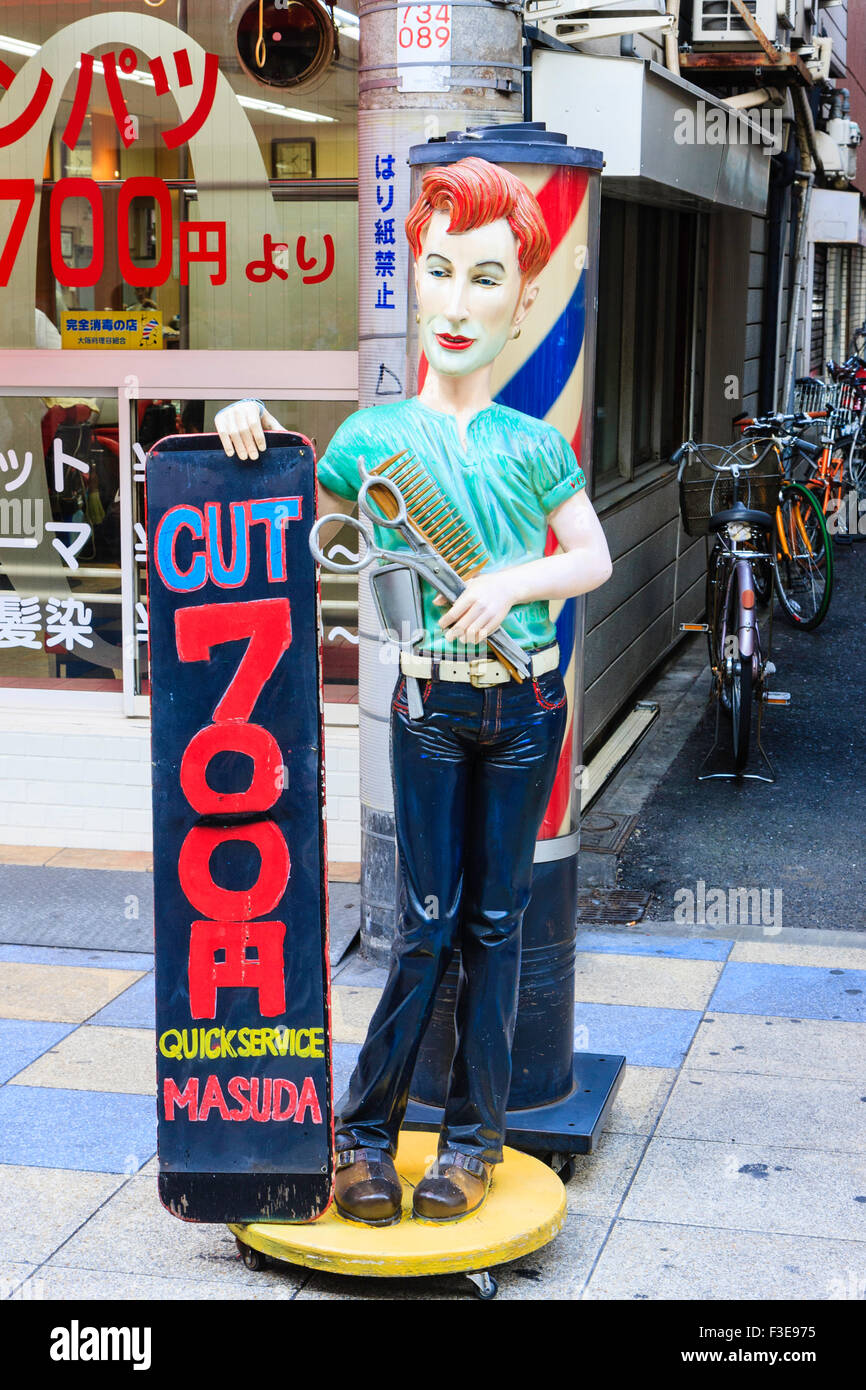 Osaka, Shinsekai. Abbildung Statue von Friseur außerhalb Friseur mit Vorzeichen bietet Haarschnitte bei 700 Yen und "quick service". Stockfoto