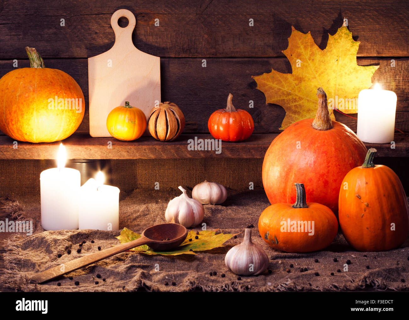 Kürbisse auf einem Holztisch mit Zubehör für die Küche Stockfoto
