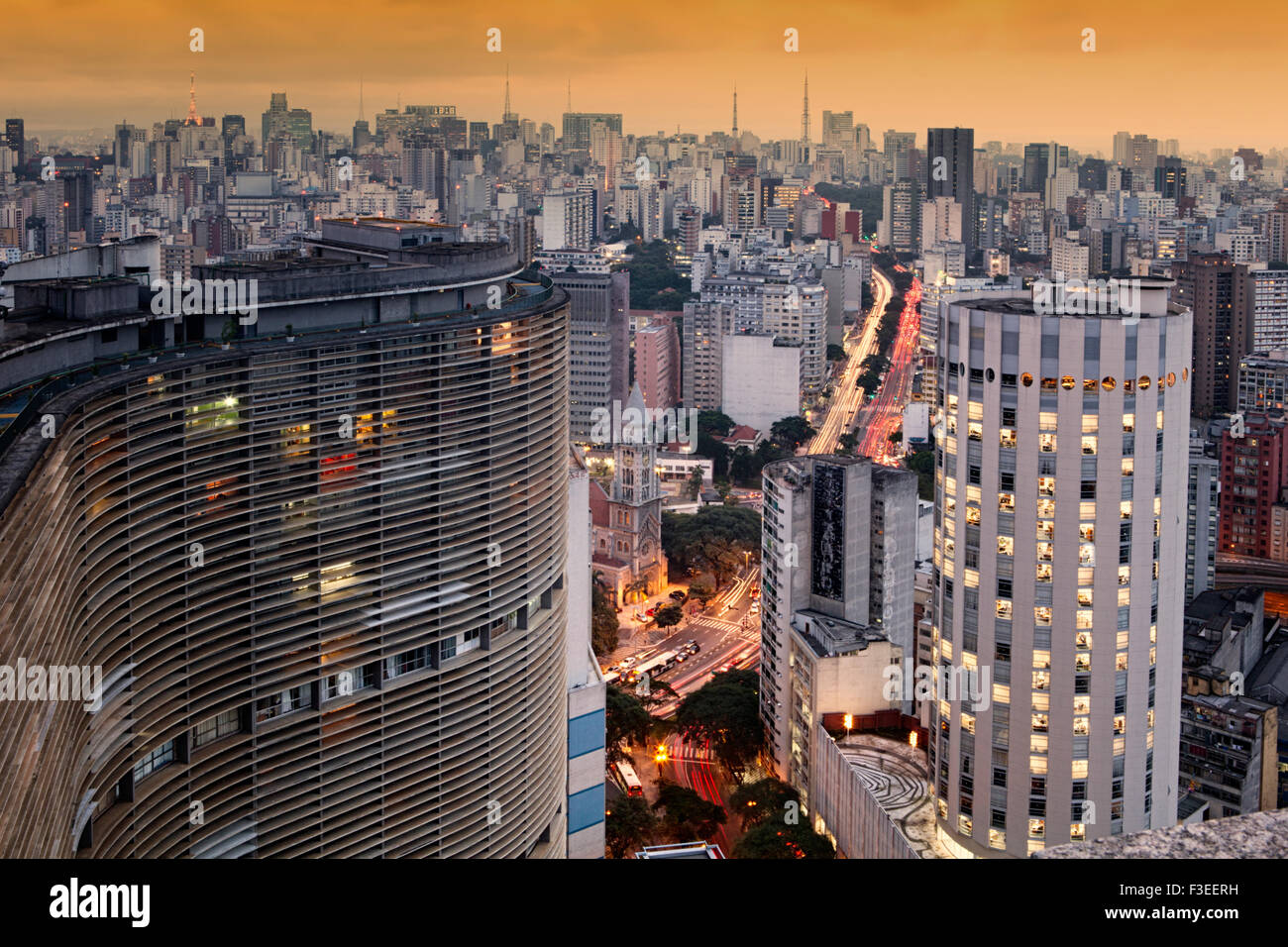 Blick auf die Skyline von Sao Paulo mit Verkehr und Umweltverschmutzung von der Terraco Italia mit Niemeyers Edificio Copan im geschwungenen Gebäude im Vordergrund Stockfoto