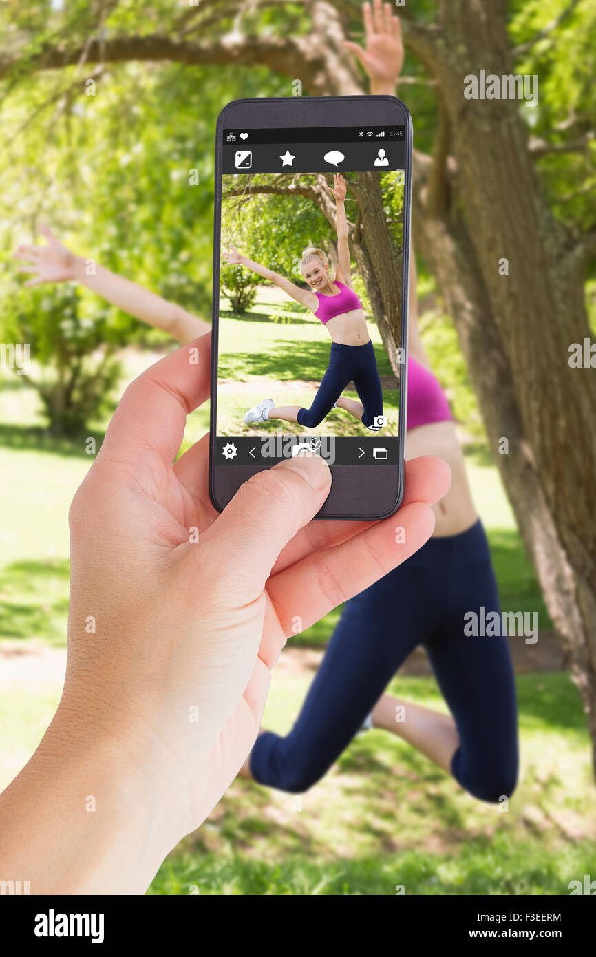 Zusammengesetztes Bild von weiblicher Hand, die eine smartphone Stockfoto