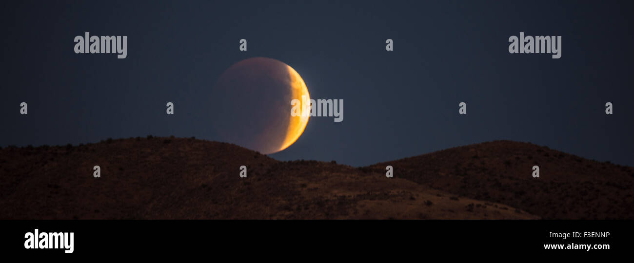 Seltene totale Mondfinsternis Super Vollmond. Halbe Eclipse steigt über die Berge, Boise, Idaho, USA Stockfoto