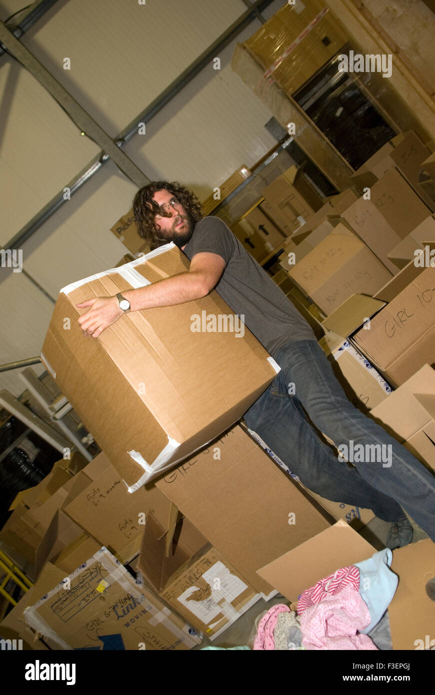 Freiwilliger in einer Reederei Lager bewegen packten gespendeten Gegenstände, Kleidungsstücke und andere nicht verderbliche Gegenstände für shippi Stockfoto