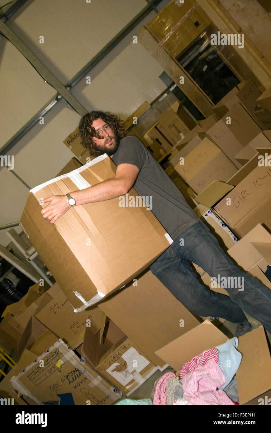 Volunteer in einem Umzugsunternehmen Lager bewegen packten gespendeten Gegenstände, Kleidungsstücke und andere nicht verderbliche Gegenstände für... Stockfoto