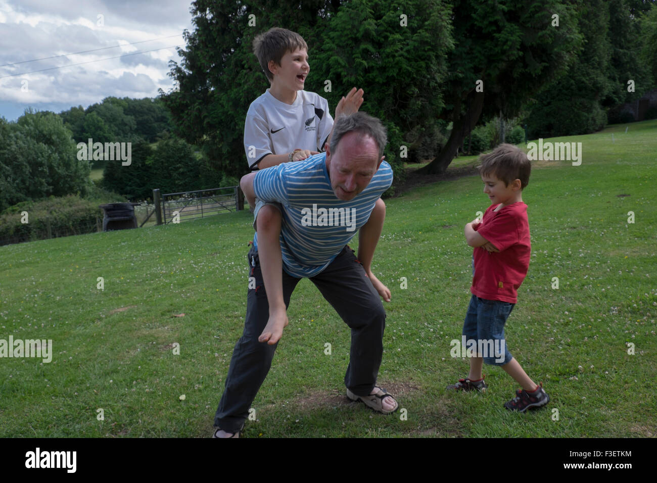 50 Jahre alter Mann spielt mit 8 Jahre alten Neffen im Garten, Monmouth, Powys, England, UK Stockfoto