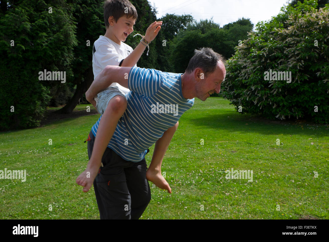 50 Jahre alter Mann spielt mit 8 Jahre alten Neffen im Garten, Monmouth, Powys, England, UK Stockfoto