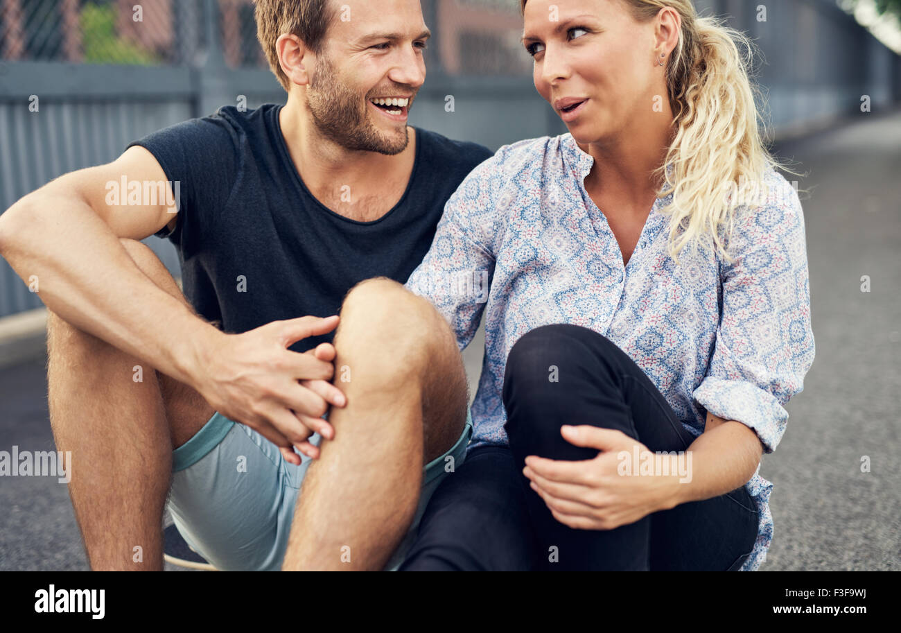 Paare, die haben einer guten Zeit beim Sitzen auf dem Boden Stockfoto