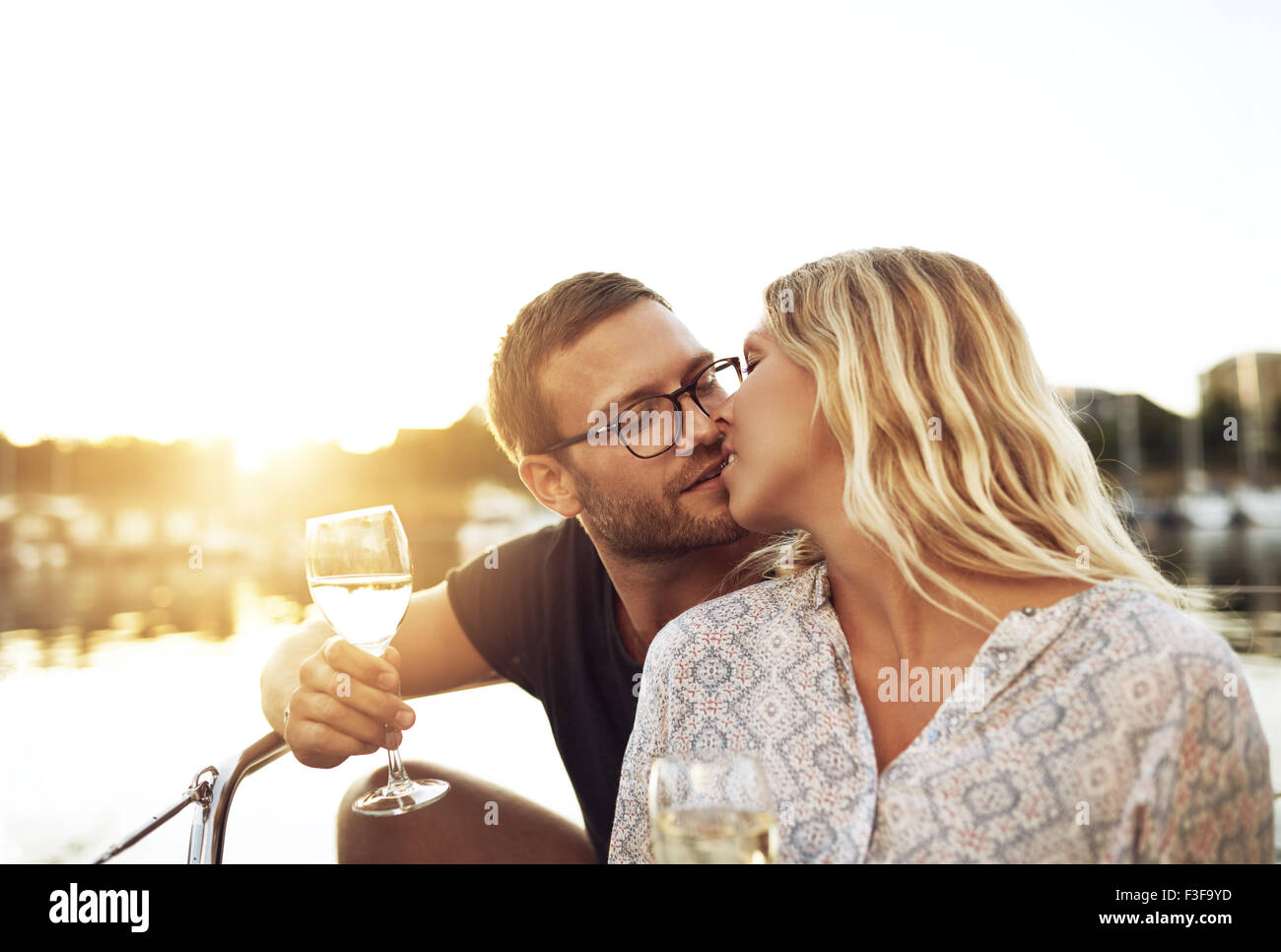 Mann und Frau küssen, sitzt auf einem Boot Stockfoto