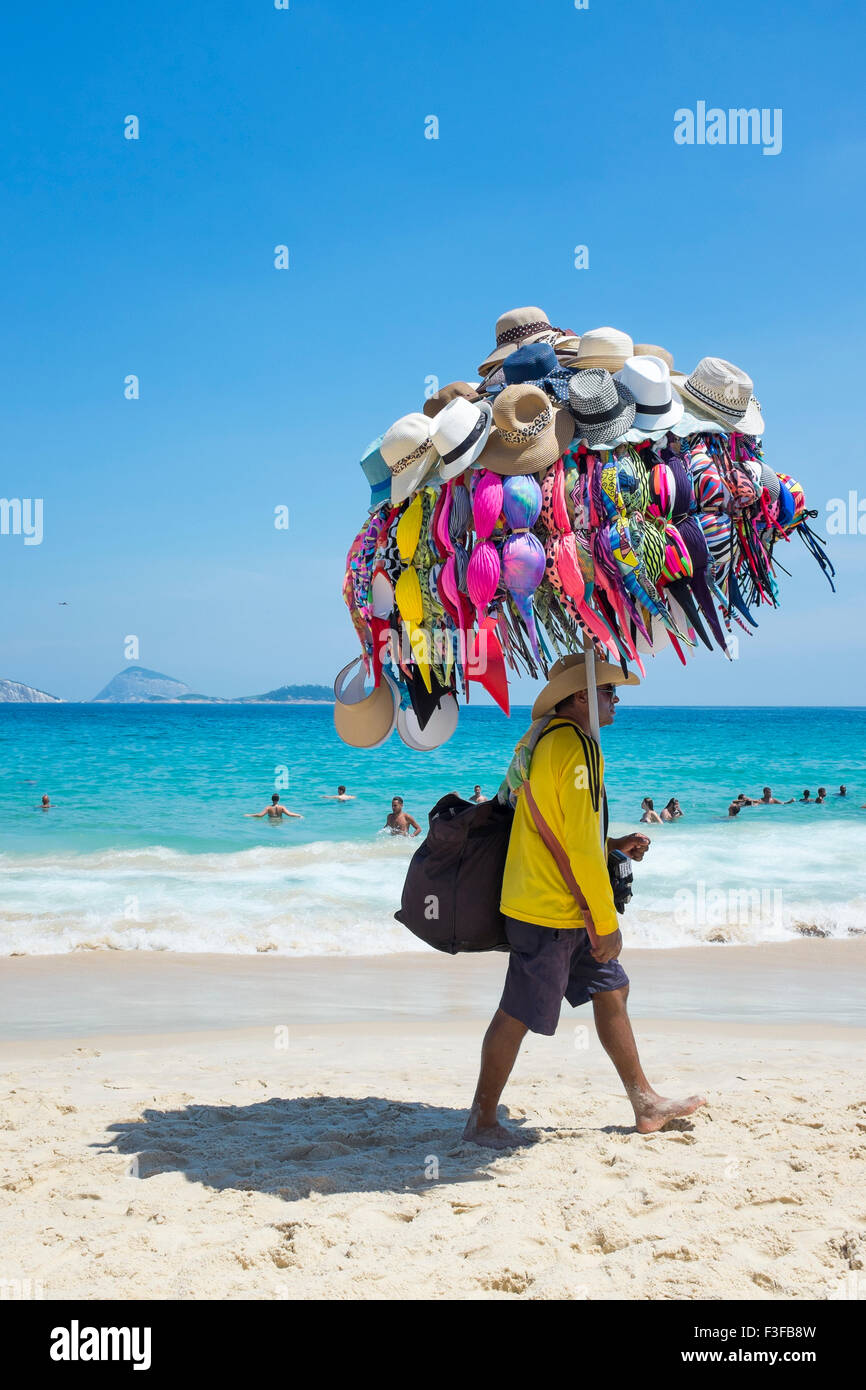 RIO DE JANEIRO, Brasilien - 22. Januar 2014: Strand Verkäufer verkaufen Bikinis und Hüte trägt seine Ware am Strand von Ipanema. Stockfoto