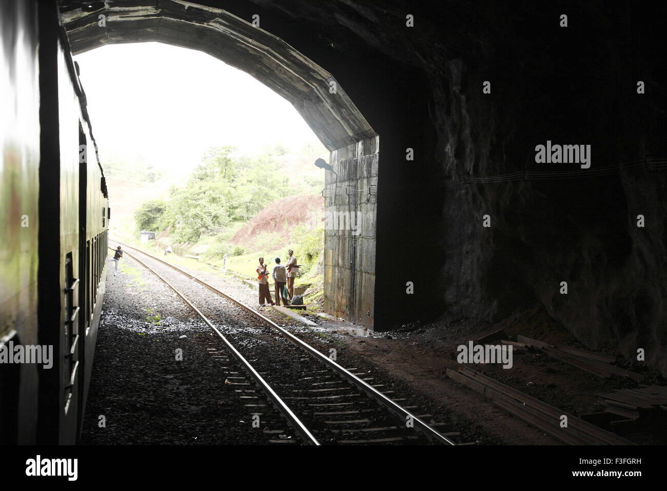 Zug durch Tunnel Eisenbahner stehend auf Eröffnung der Tunneltrasse Konkan Railway; Maharashtra; Indien nicht Herr Stockfoto