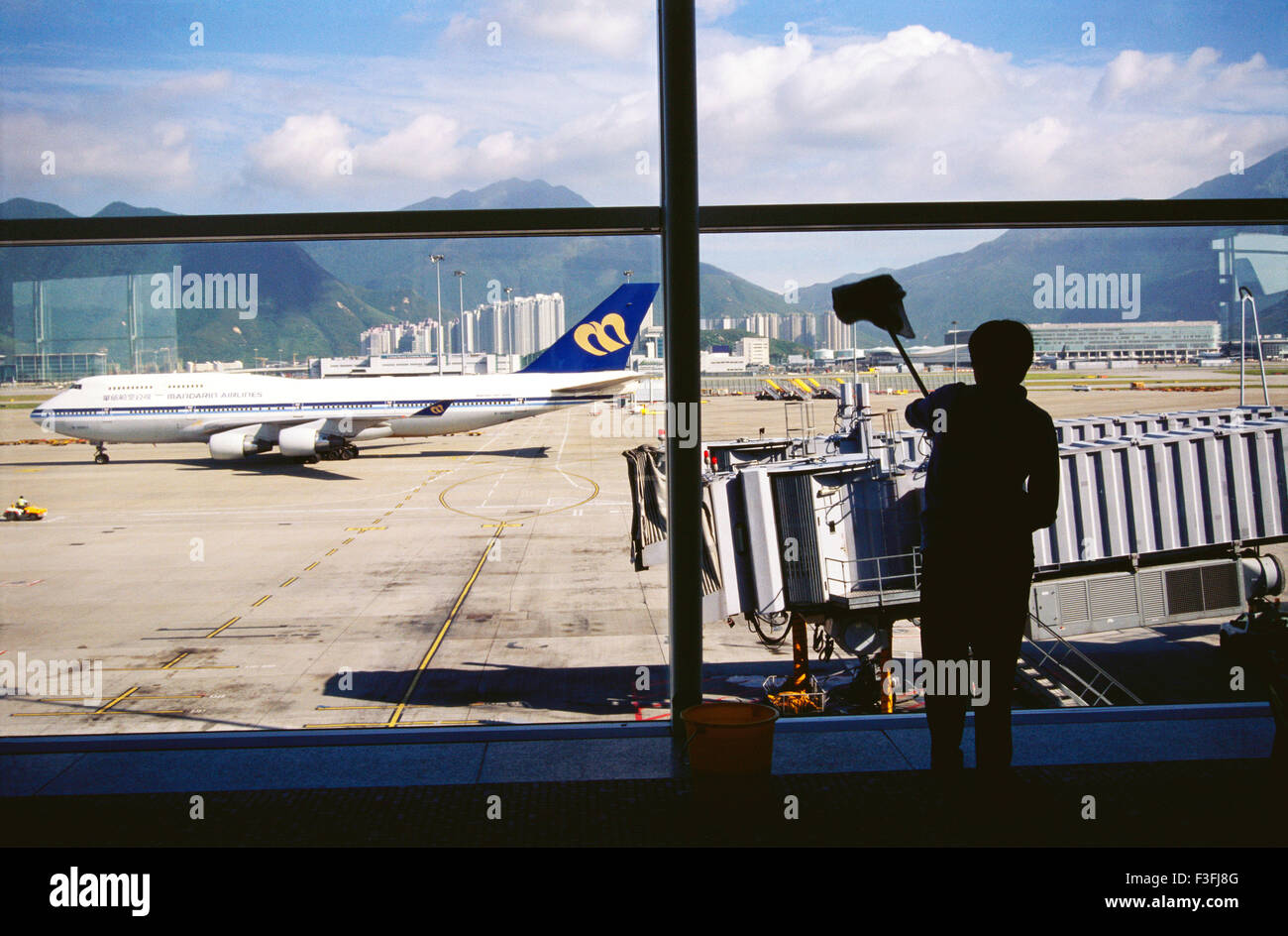 Ein chinesischer Arbeiter reinigt die Fensterscheiben des Pekinger Flughafens; China Stockfoto