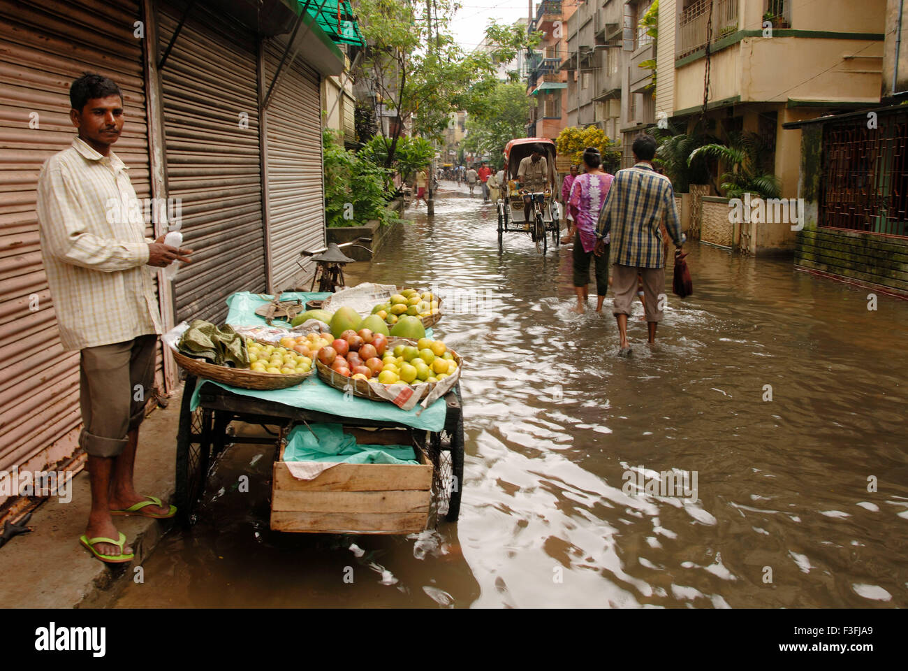 Obst-Verkäufer auf über überfluteten Straße verkaufen Obst; Indien Stockfoto