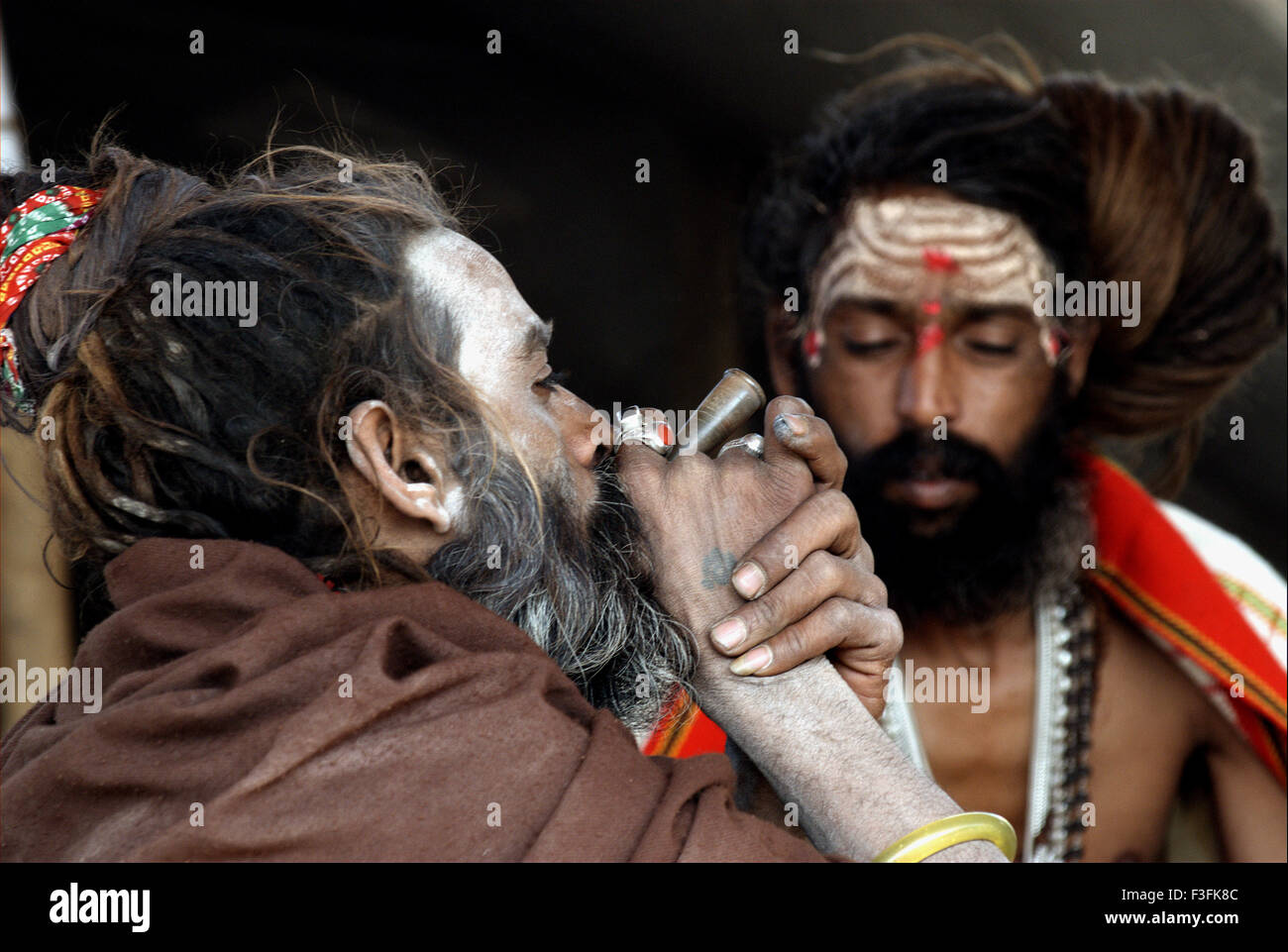 Sadhus von Juna Akadha Rauchen Opium in ihrem Lager während der Ardh Kumbh Mela;; Indien Stockfoto