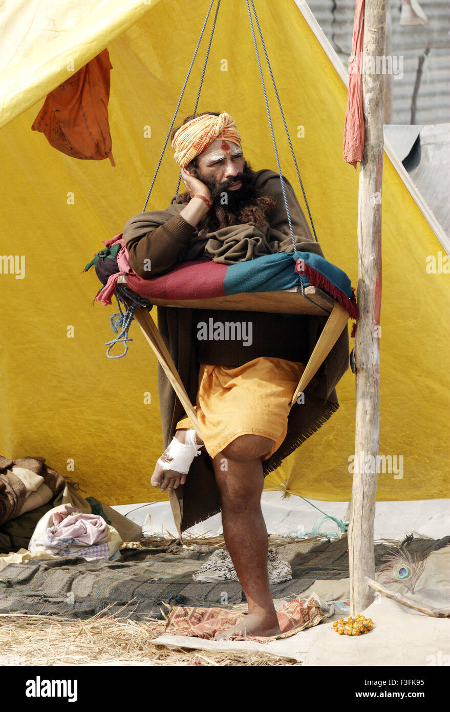 Ein Sadhu von Juna Akadha sitzt mit seinem Trishul an ihr Lager während der Ardh Kumbh Mela;; Indien Stockfoto