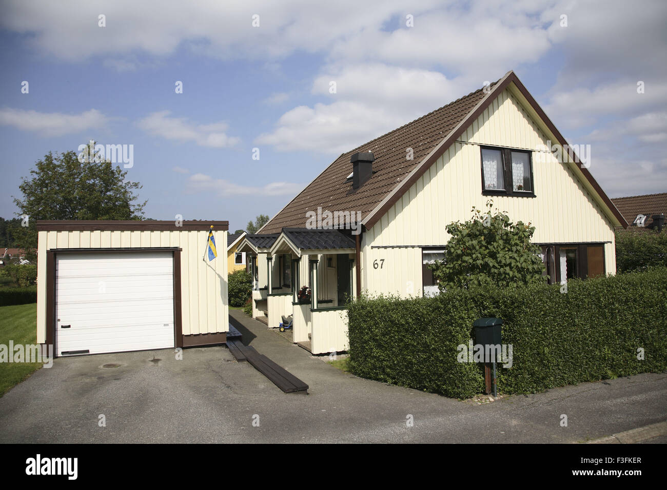 Haus oder eine Villa mit grünen Zaun von Büschen zusammengesetzte und Garage; Skepplanda; Schweden-Property-Release No.703L Stockfoto