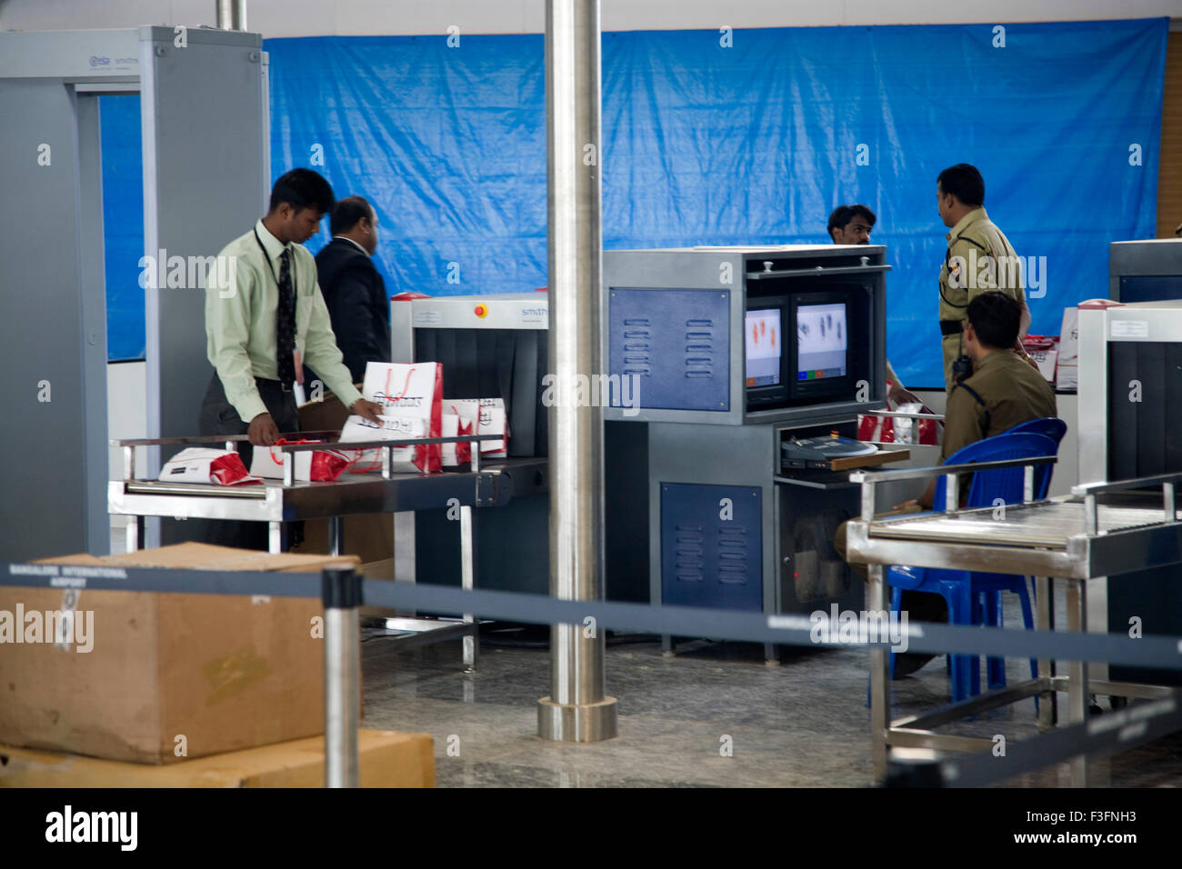 Sicherheits-Check; Pflicht-Offiziere Scannen das Gepäck durch Monitore; Bengaluru internationaler Flughafen; Bangalore Stockfoto