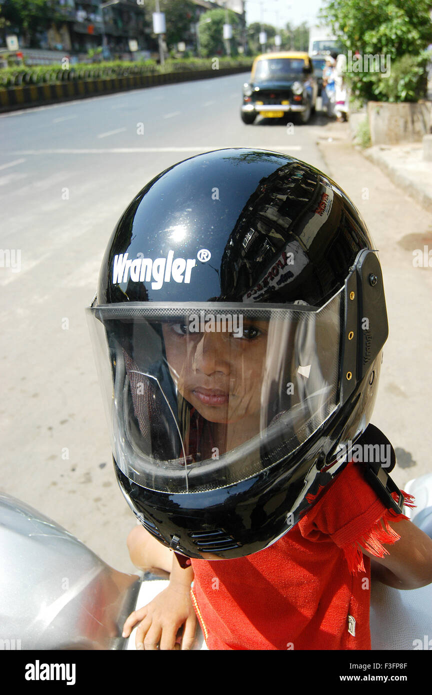 Junge trägt Helm sitzt auf zwei Wheeler oder Motorrad in Bombay Mumbai; Maharashtra; Indien nicht Herr Stockfoto