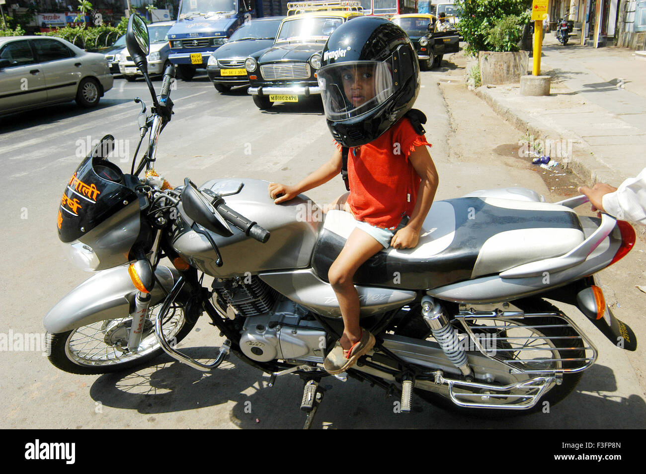 Junge trägt Helm sitzt auf zwei Wheeler oder Motorrad in Bombay Mumbai; Maharashtra; Indien nicht Herr Stockfoto
