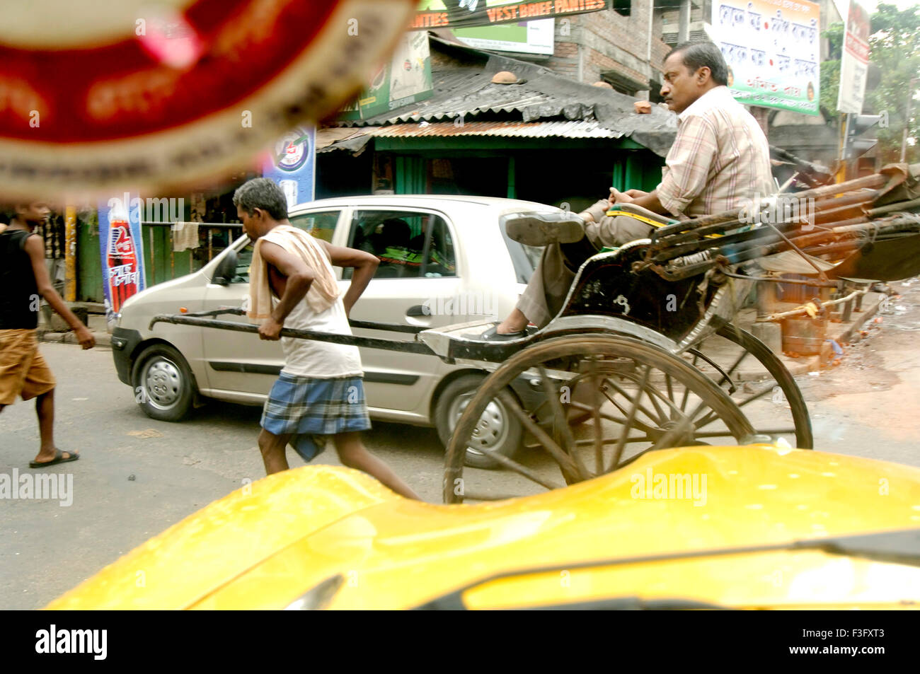 Leben in der Stadt; Rikscha-Puller mit Passagier auf Straße von Kalkutta ziehen die Hand jetzt Kolkata; Westbengalen; Indien Stockfoto
