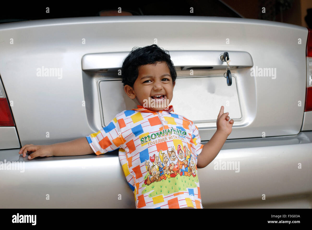Glücklicher Junge, der in der Nähe des neuen Autos STEHT HERR#7 HERR#777I Stockfoto
