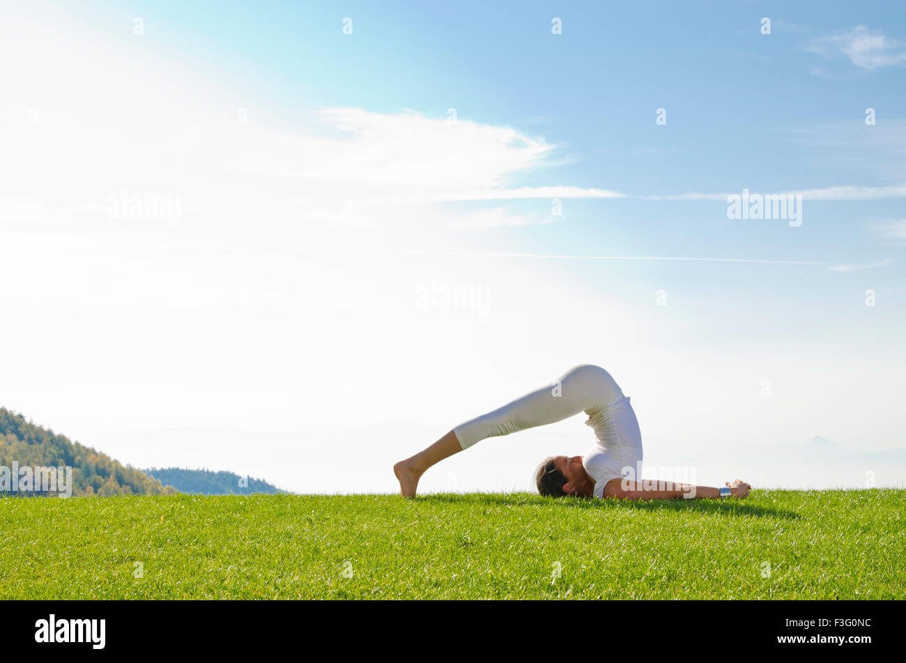 Junge Frau praktizieren Hatha-yoga Outdoor, zeigt die Pose halasana, Pflug Stockfoto