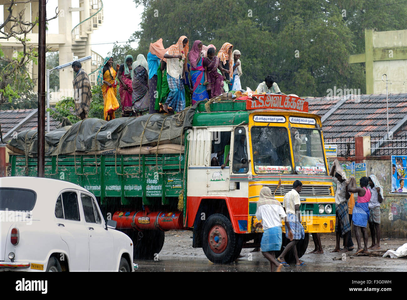 Kulis, stehend auf einem Lastwagen an einem regnerischen Tag; Tamil Nadu; Indien Stockfoto