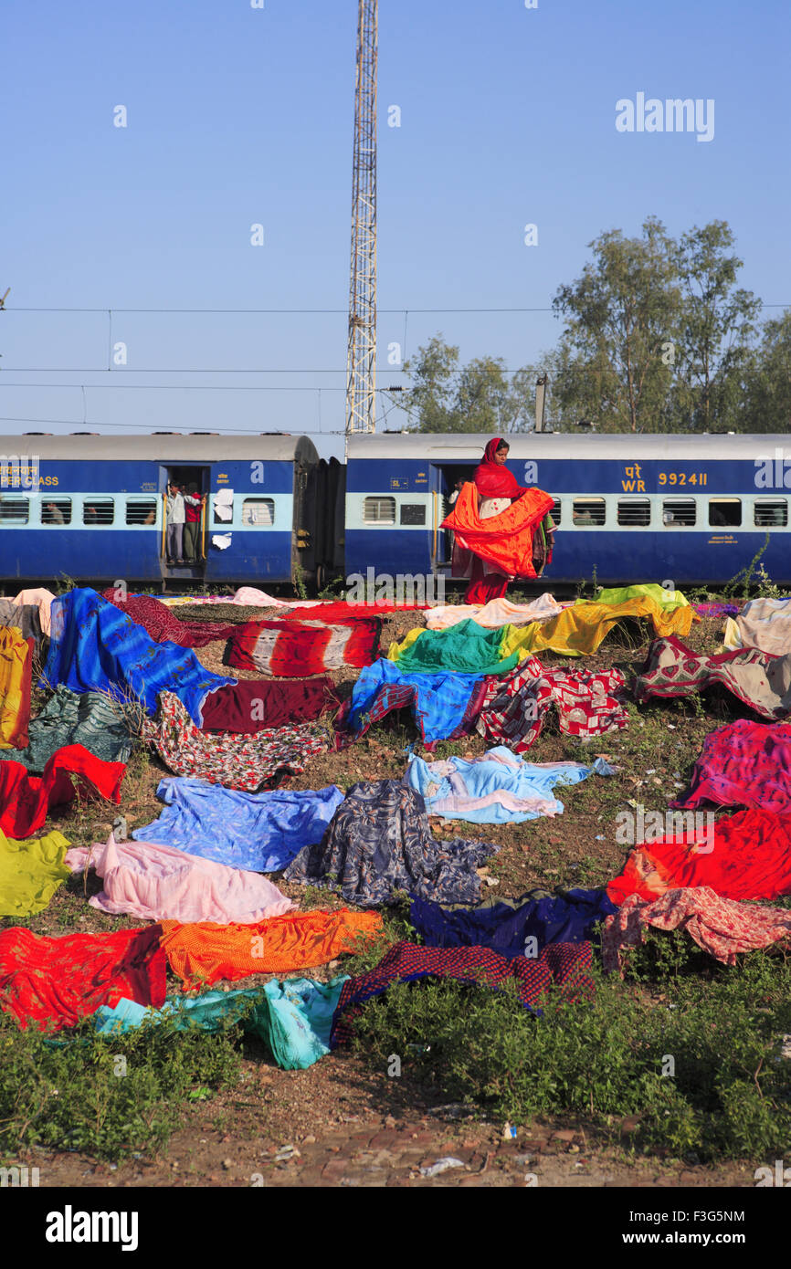 Frau Trocknen von Kleidung im Freien im Hintergrund der indischen Eisenbahn; Agra; Uttar Pradesh; Indien Stockfoto