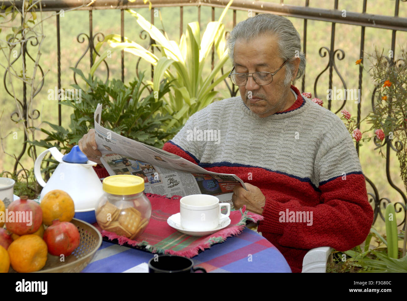 Achtzig Jahre alte Senioren genießen Morgen Tee auf der Terrasse sitzen und lesen Zeitung am Kalyaninagar; Pune Stockfoto