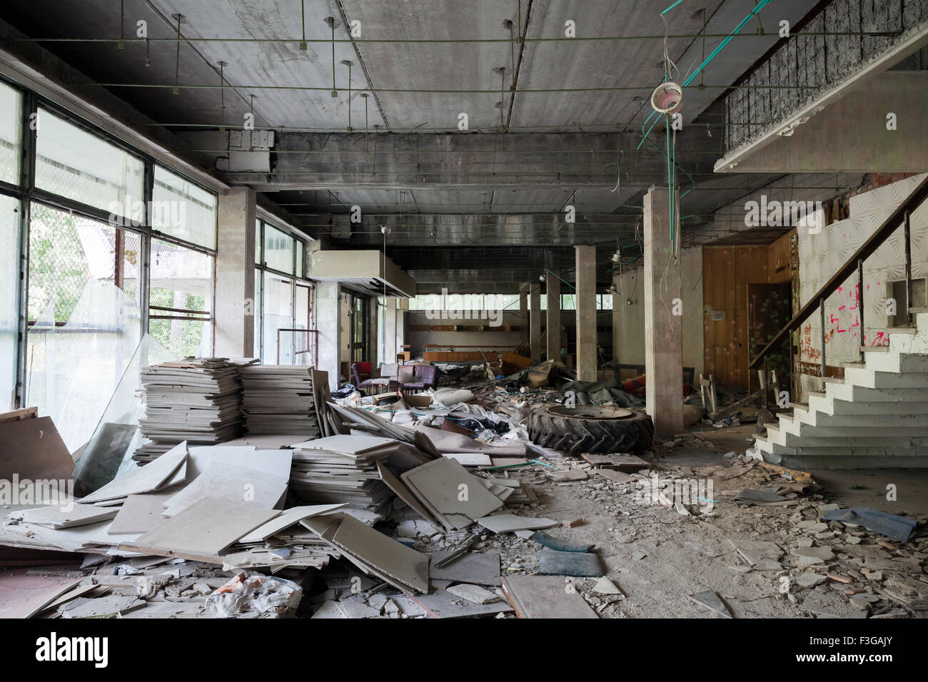 Verlassene Gebäudeinnenraum. Korridor-Perspektive mit Schmutz auf dem Boden und zerbrochenen Fensterscheiben Stockfoto
