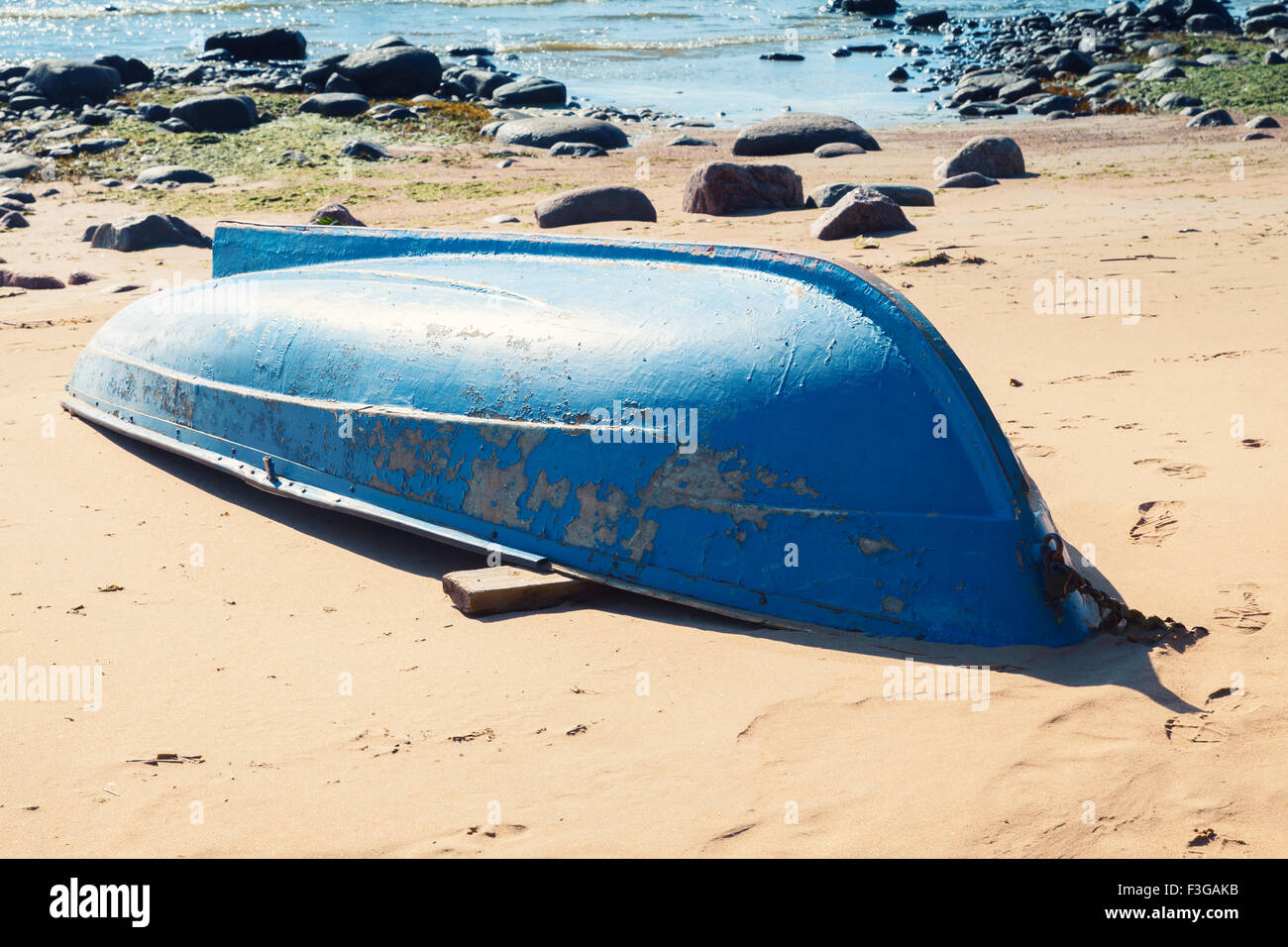 Alte blaue Ruderboot liegt am Sandstrand. Golf von Finnland, Russland Stockfoto
