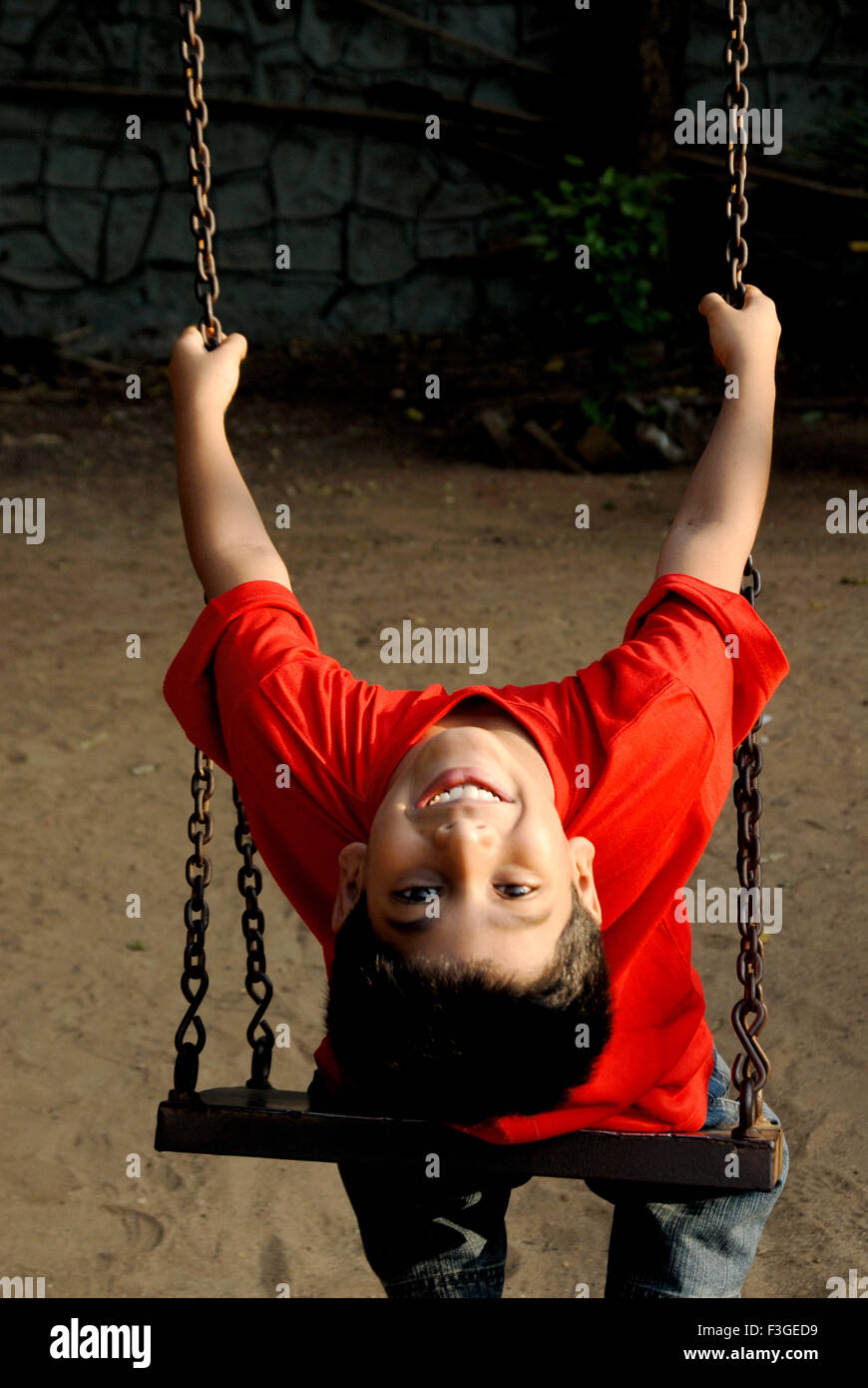 Indischer Junge im roten T-Shirt auf Swing zurück suchen, Indien - HERR Nr. 152 Stockfoto