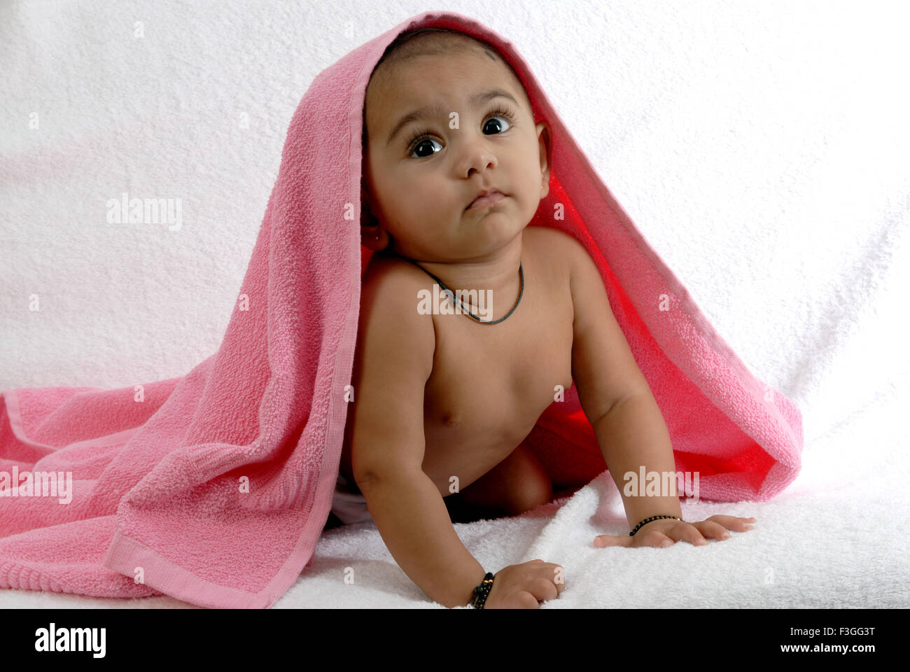 Südasiatische indischen Baby; Decken Sie ihren Kopf mit einem rosa Handtuch; Indien Herr #152 Stockfoto