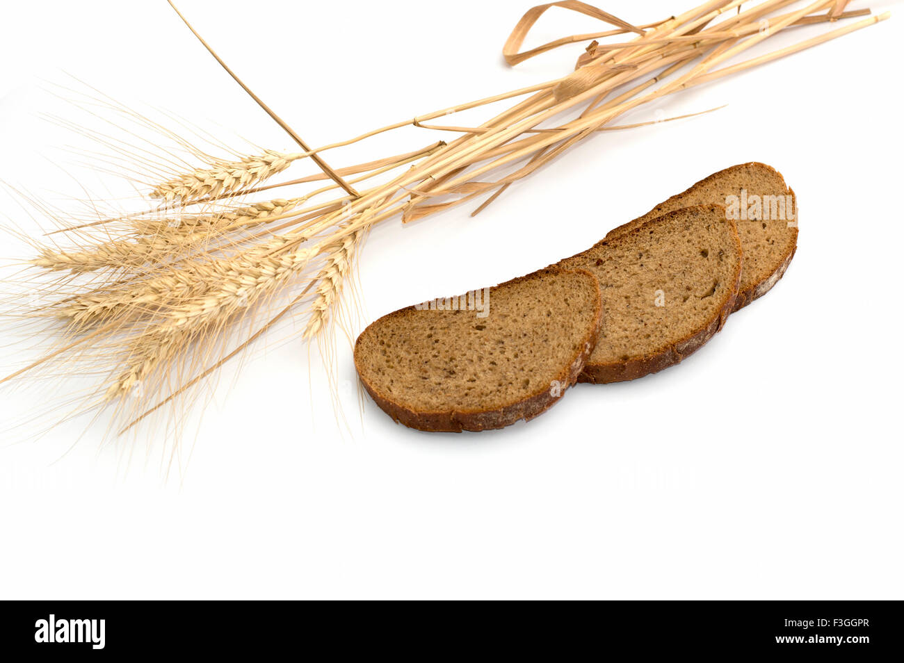 die Ohren des Weizens und drei Stücke Brot, die hintereinander ein Stillleben angeordnet werden Stockfoto