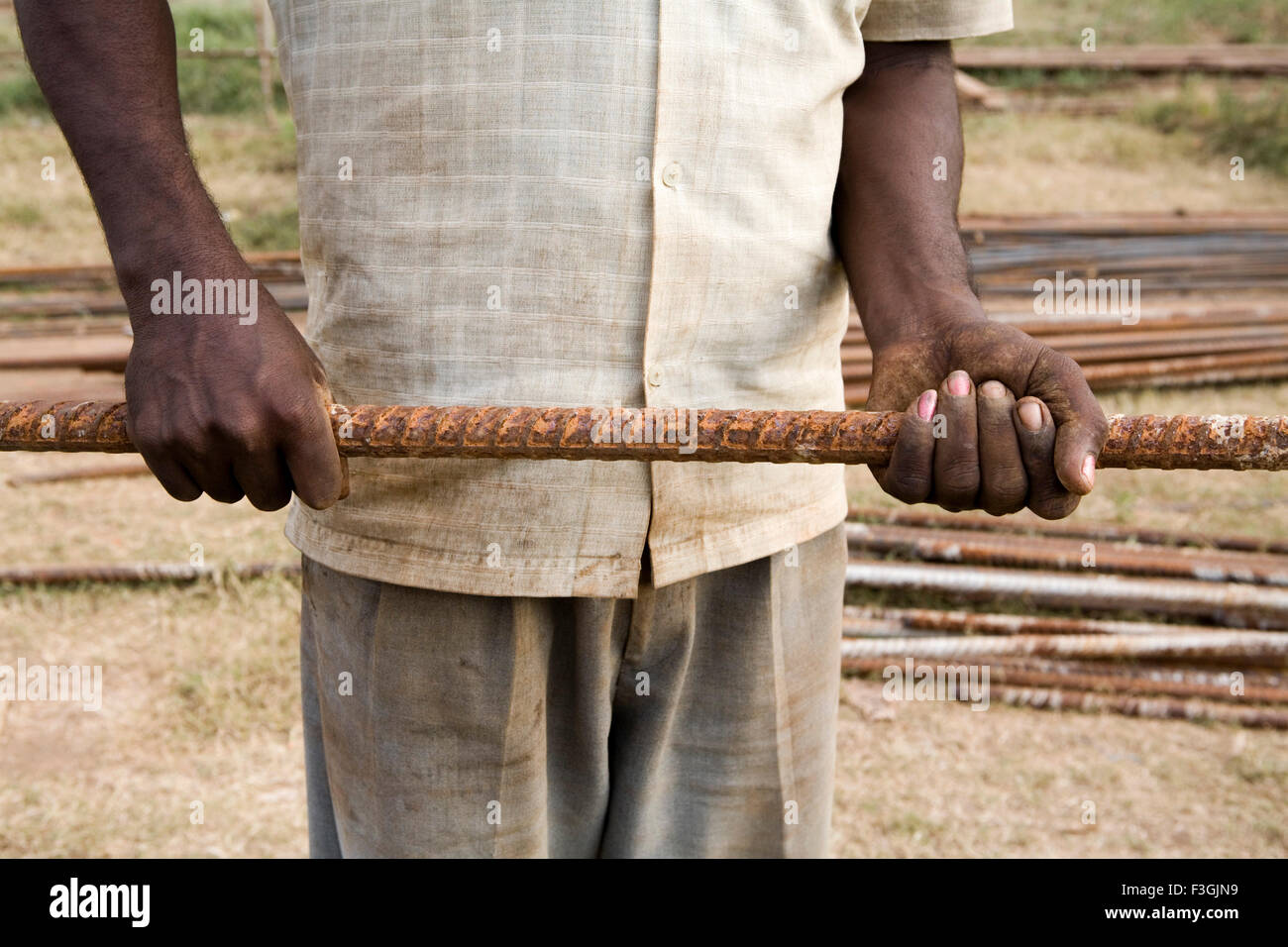 Ein Bauarbeiter, Umgang mit Eisen Straßen mit seinen Händen tragen; Ahmedabad; Gujarat; Indien Stockfoto