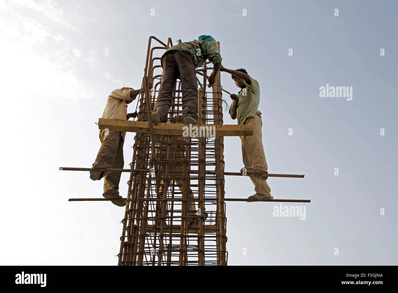 Arbeiter einer prekären ohne Sicherheitsgurte und Helme stehen und arbeiten auf einer Baustelle; Ahmedabad; Gujarat Stockfoto