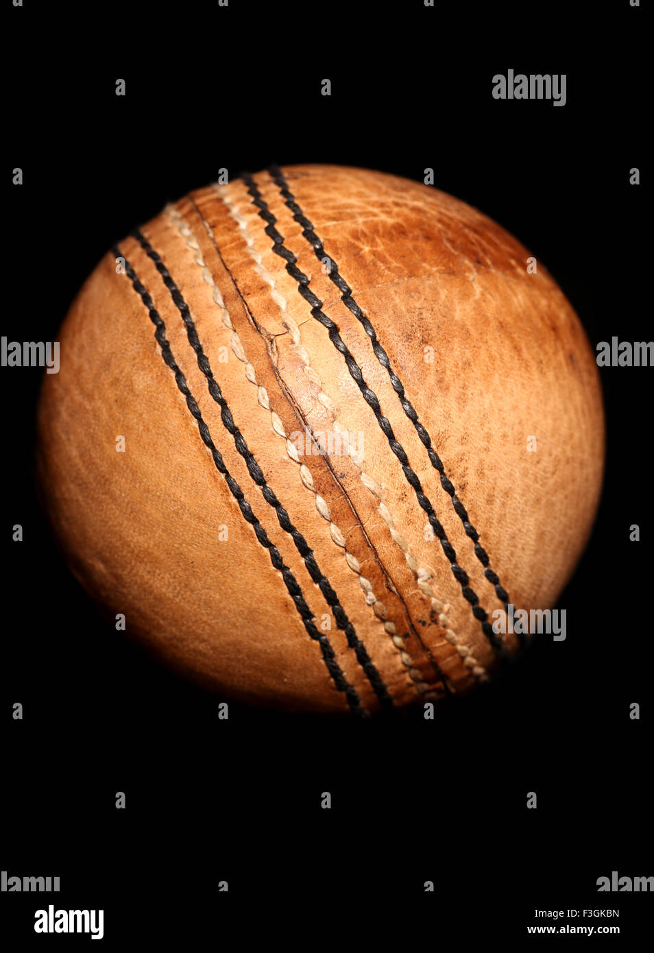 Vintage-Stil Cricketball auf schwarzem Hintergrund Stockfoto