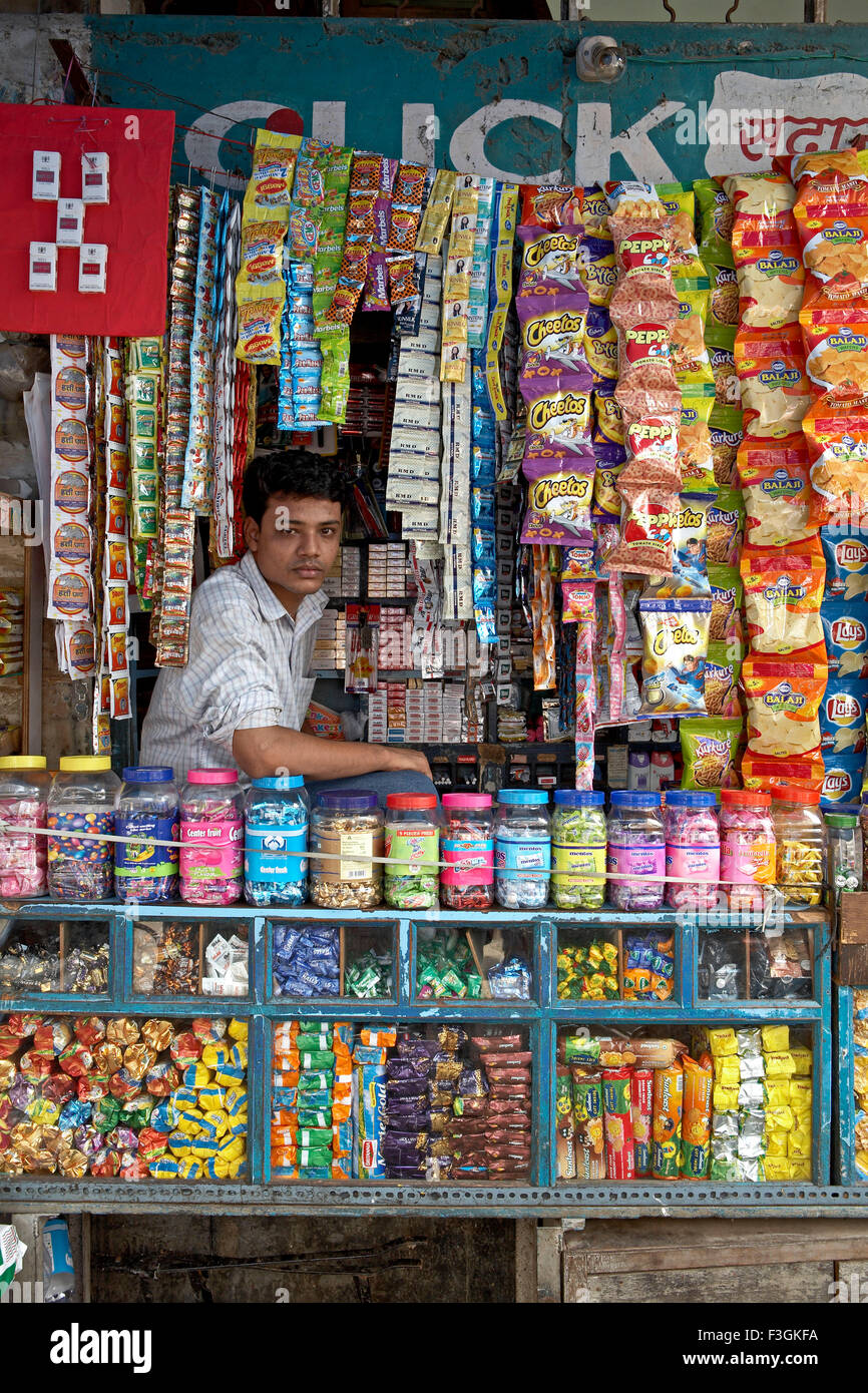 Ein Anbieter verkaufen Zigaretten; Toffees; Kekse; übersichtlich und attraktiv dargestellt in seinem kleinen Laden usw. Mumbai Stockfoto