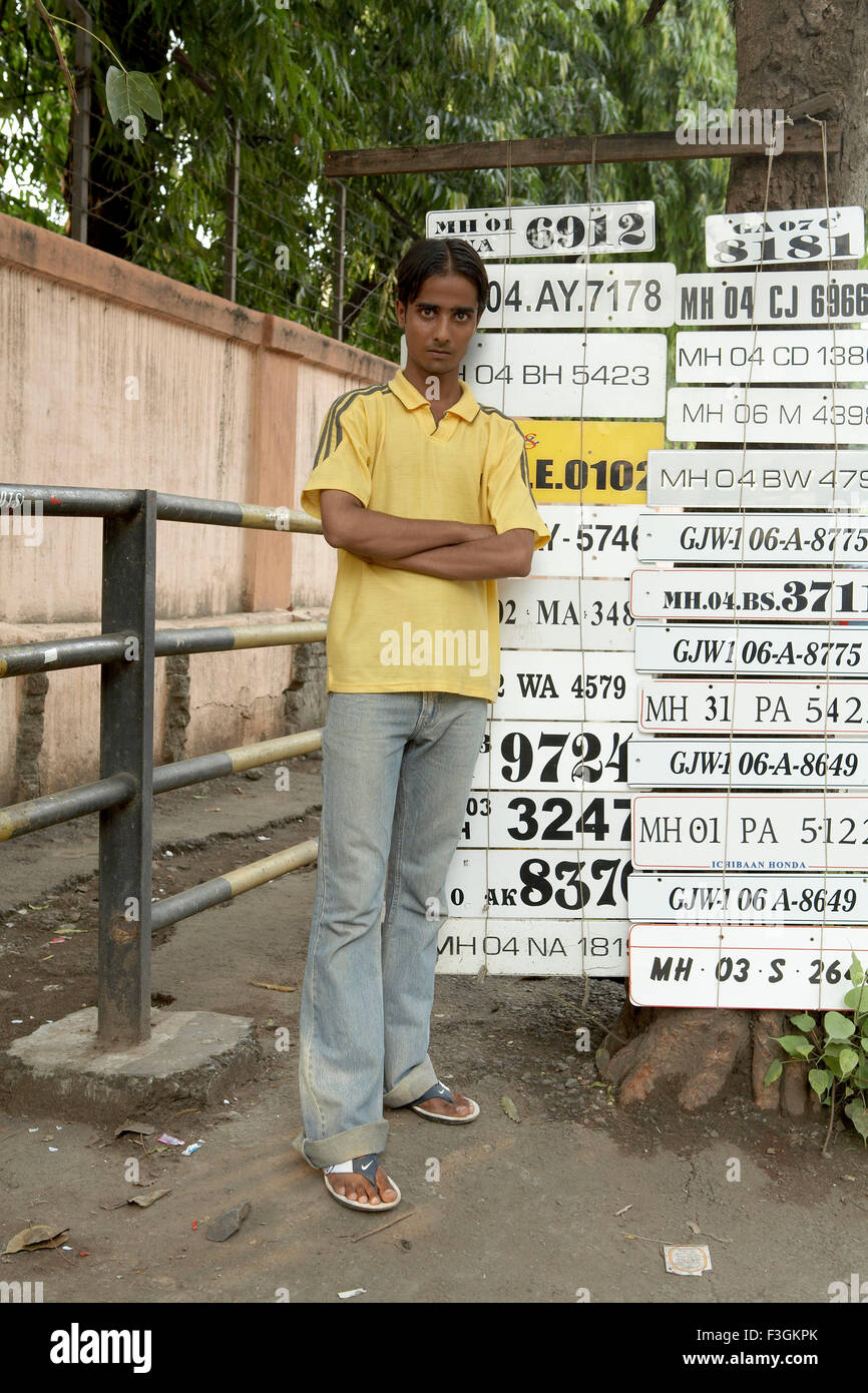 Ein Fahrzeug Nummer Platte Graveur Künstler mit der Anzeige der verschiedenen Entwürfen am Straßenrand; Mumbai-Bombay Stockfoto