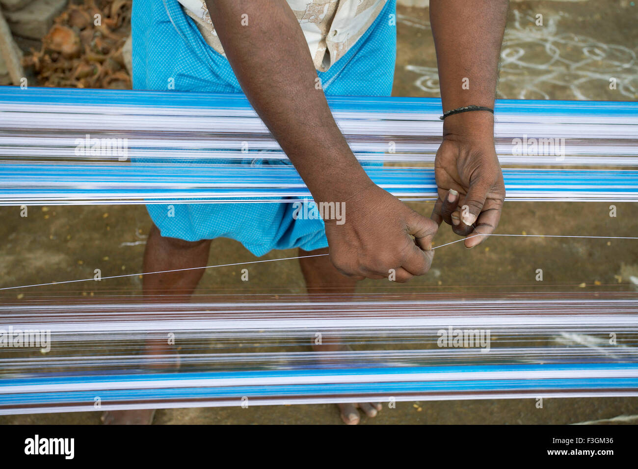 Vorbereitung der textilen Kette durch den zart Beitritt jedes Stück gebrochen Garn mit geschickten Händen; Kanchipuram; Tamil Nadu Stockfoto