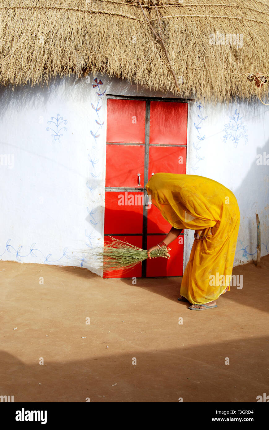 Lady fegen Staub von Besen im Haus; Jodhpur; Rajasthan; Indien Stockfoto