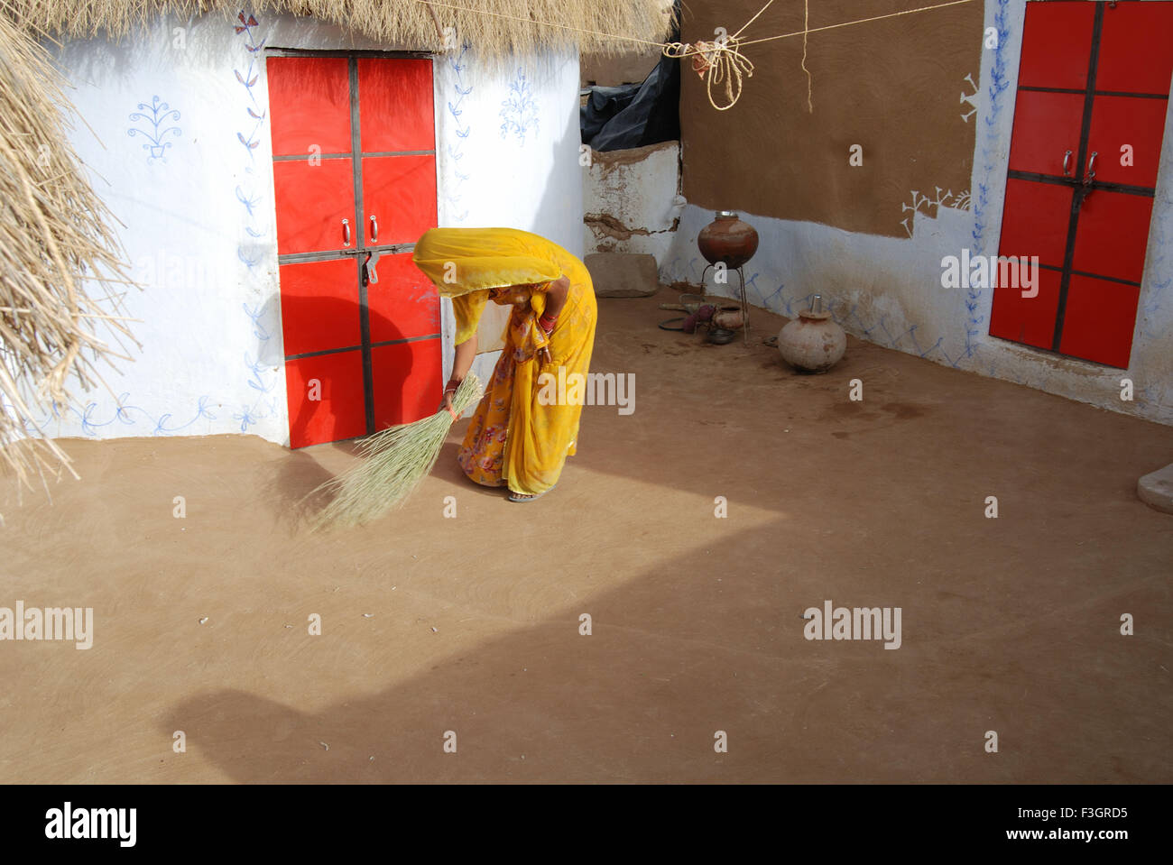 Lady fegen Staub von Besen im Haus; Jodhpur; Rajasthan; Indien Stockfoto