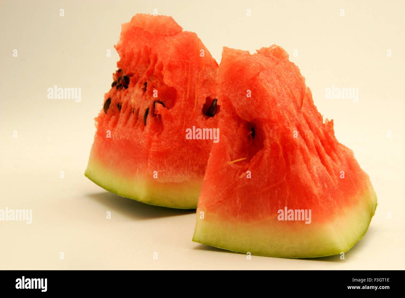 Früchte; Zwei Stücke Wassermelone roten wässrige Fruchtfleisch vor weißem Hintergrund zeigt; Pune; Maharashtra; Indien Stockfoto