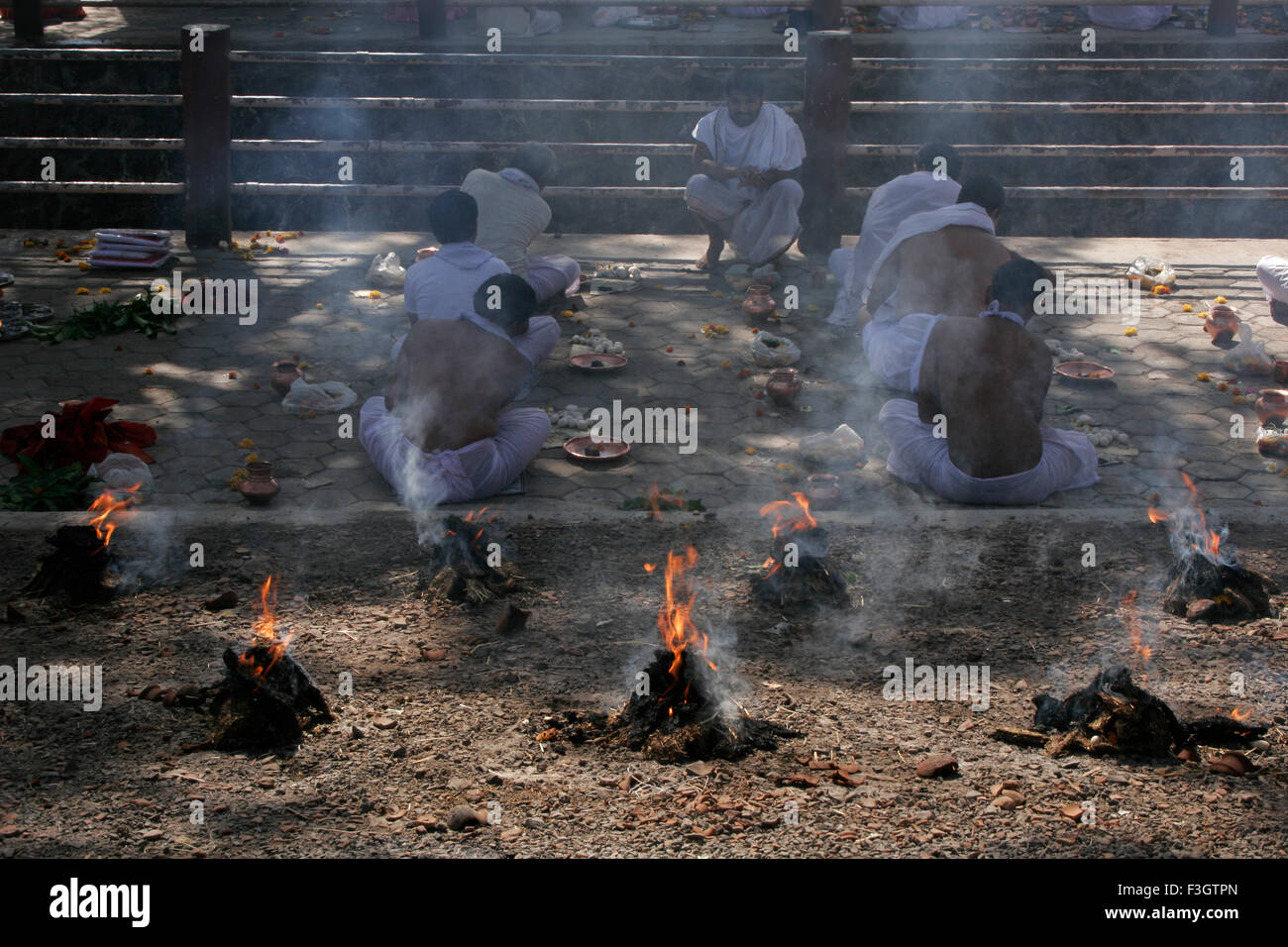 Traditionelle und übliche Zeremonien genannt Shraad Puja durchgeführt durch sieben indische Männer inmitten Feuer Rauch geliebten Trambak Nashik Stockfoto